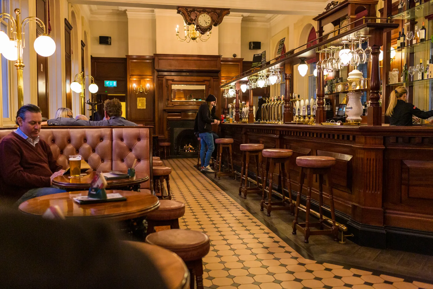 Inside Harrogate Tap: the long wood-panelled bar, leather booths and tiled floor